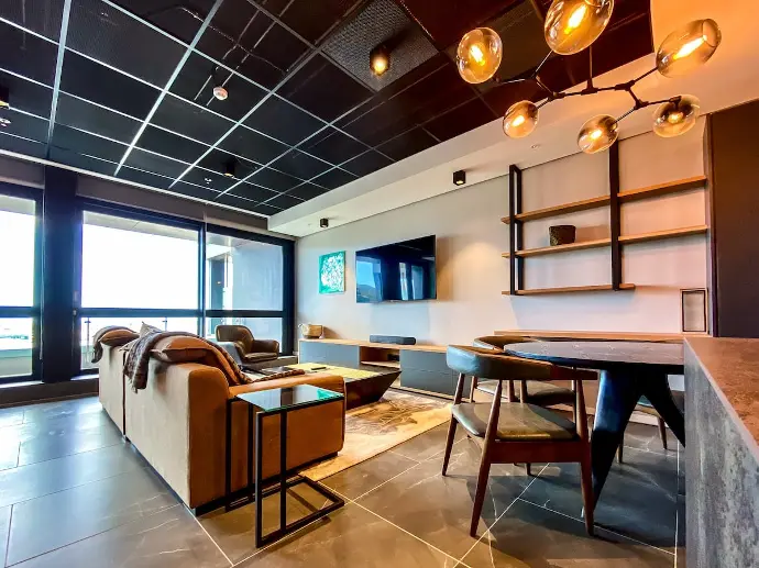 A sleek living room with a big flat screen TV, perfect for cozy movie nights and immersive gaming sessions. A modern living room with a big flat screen TV.