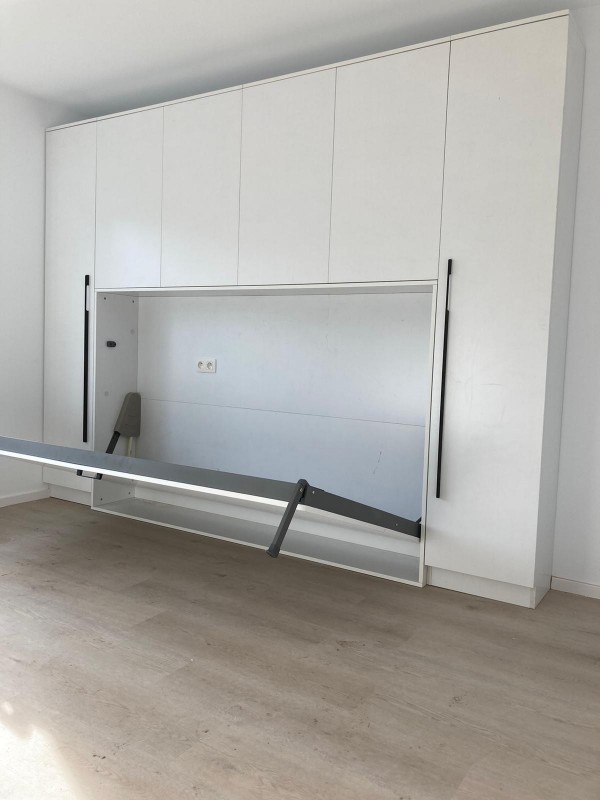 a white room with a large white wall and a white cabinet