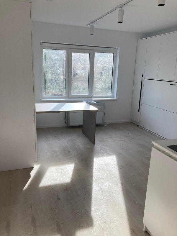 An empty room featuring a table and a window.