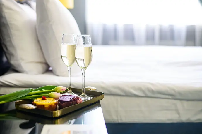 Bed tray with champagne and floral arrangement Champagne and flowers on bed tray