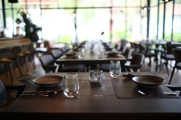 inviting restaurant table set with empty plates and utensils, awaiting a scrumptious feast. restaurant table with empty plates and utensils, ready for a delicious meal to be served.