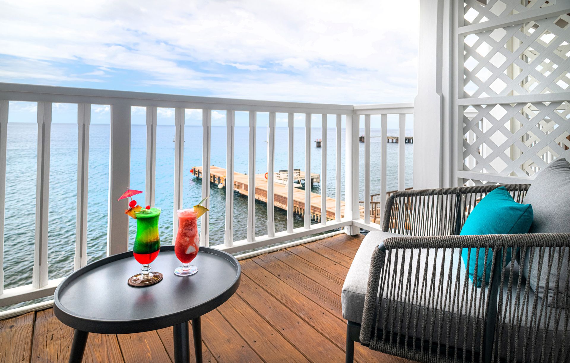 A serene balcony adorned with two elegant chairs and a tastefully arranged table, adorned with refreshing drinks, beckoning relaxation and indulgence.