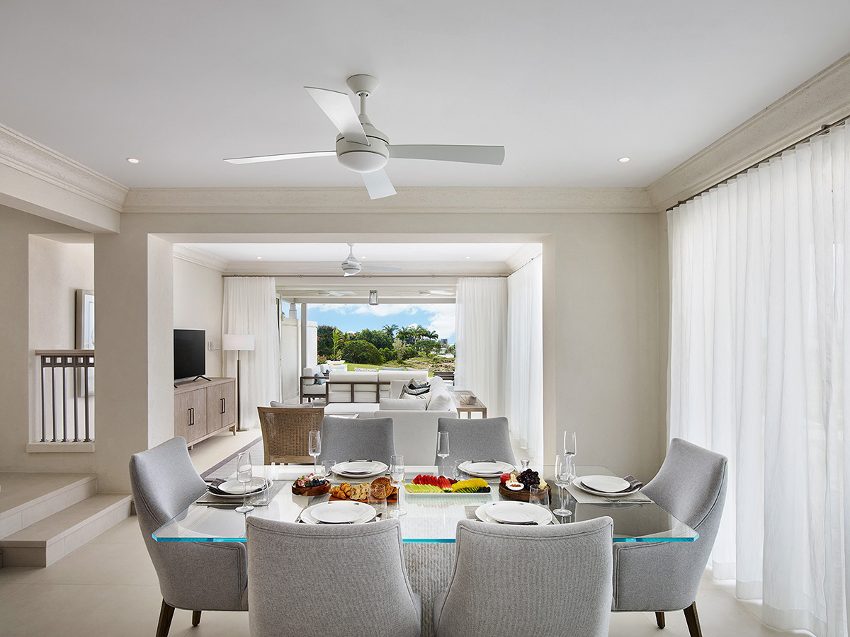 A modern dining room with a sleek glass table and comfortable chairs. Perfect for hosting dinner parties.