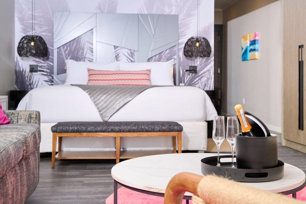 Elegant hotel room featuring a comfortable bed, chic couch, and sleek table.