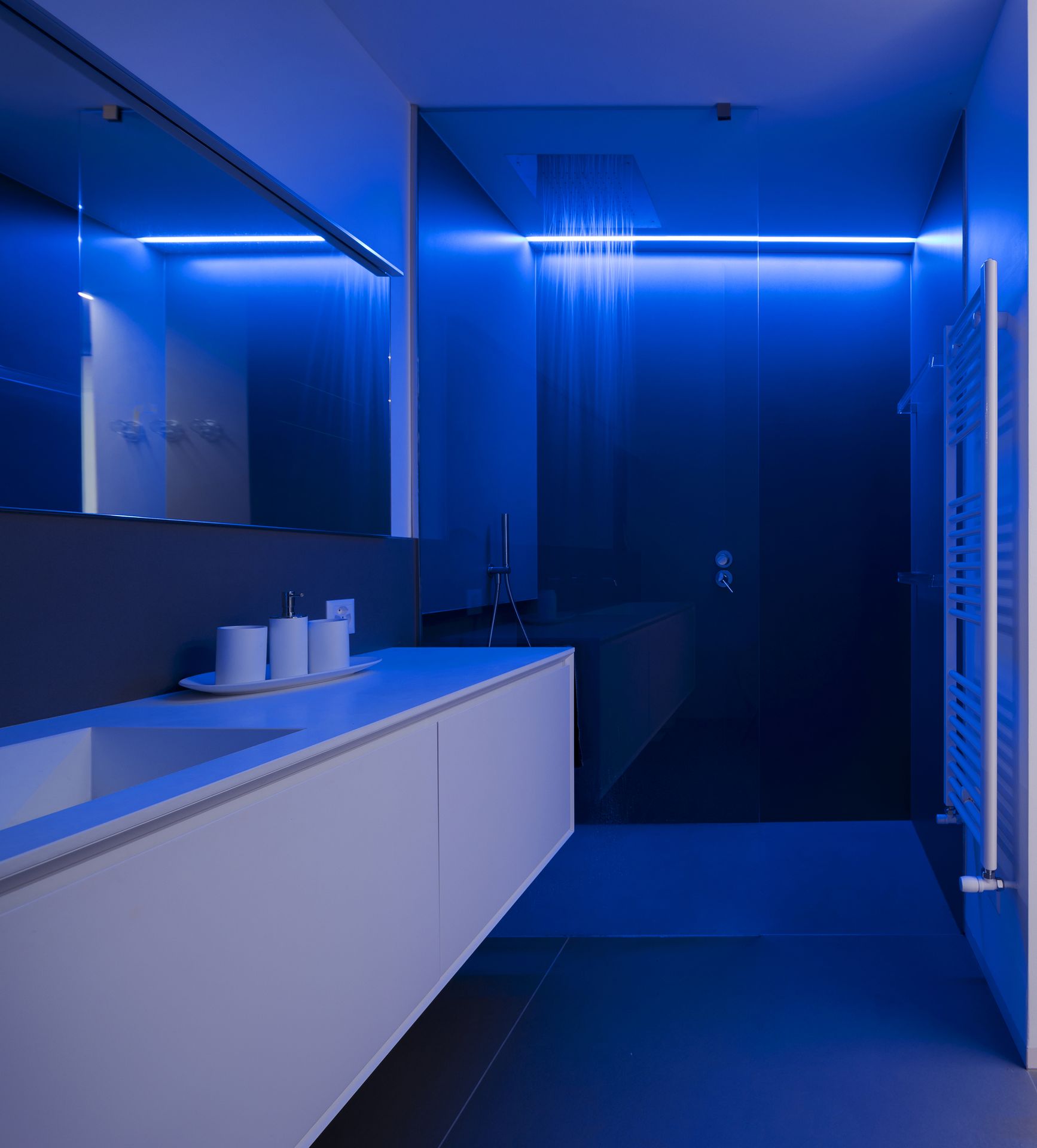 Modern bathroom featuring blue lighting and a sleek sink design