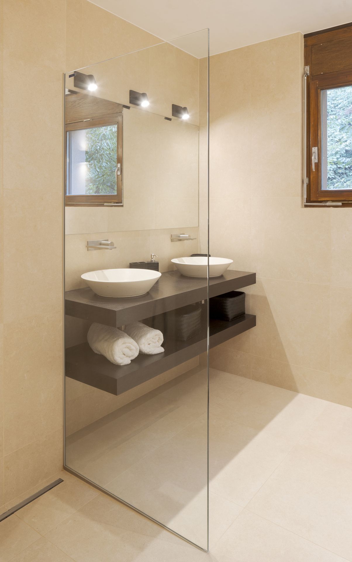 A modern bathroom with a glass shower door and a sleek sink