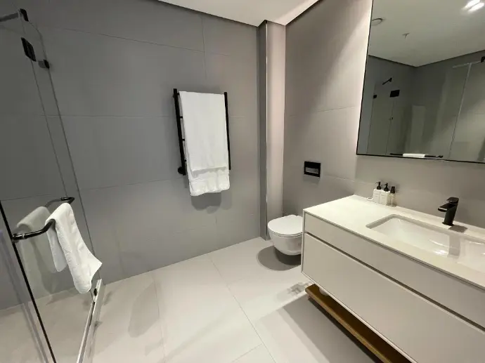 A bathroom featuring porcelain toilet, ceramic sink, and glass shower A bathroom featuring porcelain sanitary ware