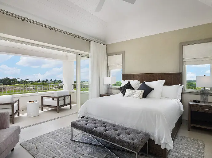 Opulent bedroom showcasing a grand bed with panoramic ocean scenery Luxurious bedroom with king-sized bed overlooking the vast ocean.