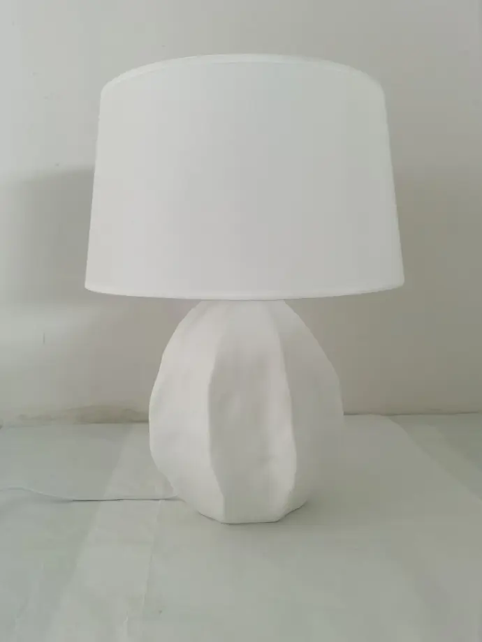 A minimalist white table lamp A white table lamp