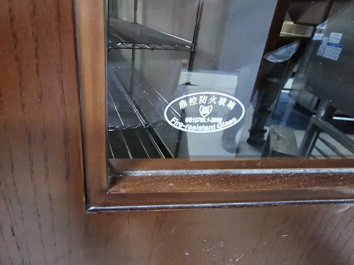 Fire-rated Doors A glass on a door with a label reading: Fire resistant glass